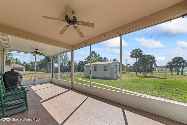 unfurnished sunroom featuring ceiling fan