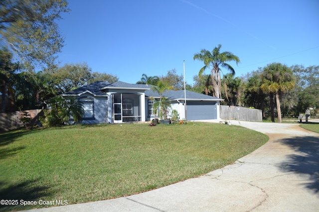 ranch-style house featuring an attached garage, concrete driveway, a front lawn, and fence