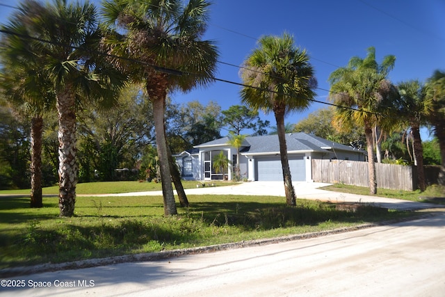 view of front of home featuring a garage, driveway, a front lawn, and fence