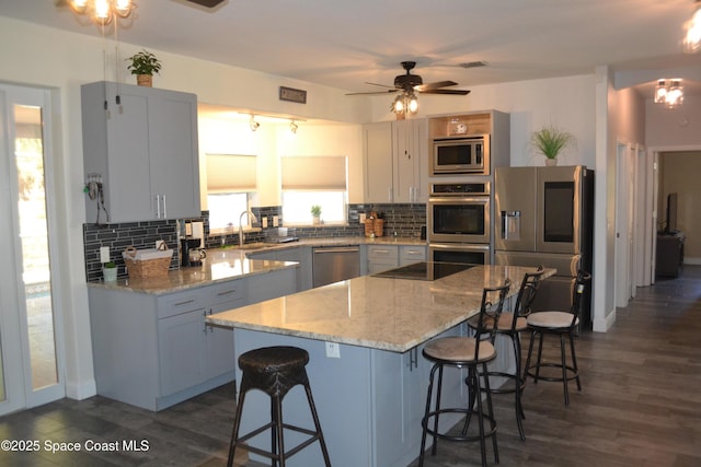 kitchen featuring decorative backsplash, a breakfast bar area, and appliances with stainless steel finishes