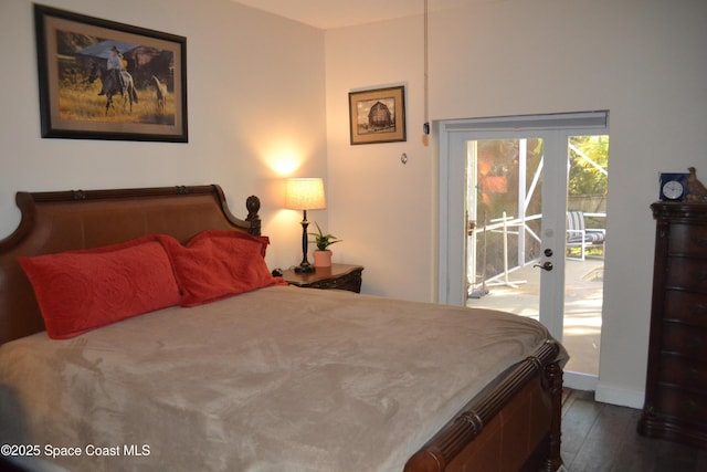 bedroom with dark wood-style floors, baseboards, and access to outside