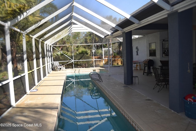 pool with a patio area, area for grilling, and glass enclosure