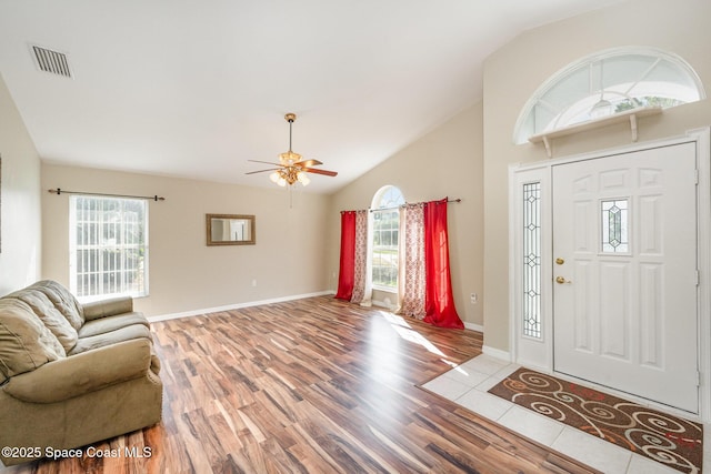 entryway with lofted ceiling, wood finished floors, visible vents, and baseboards