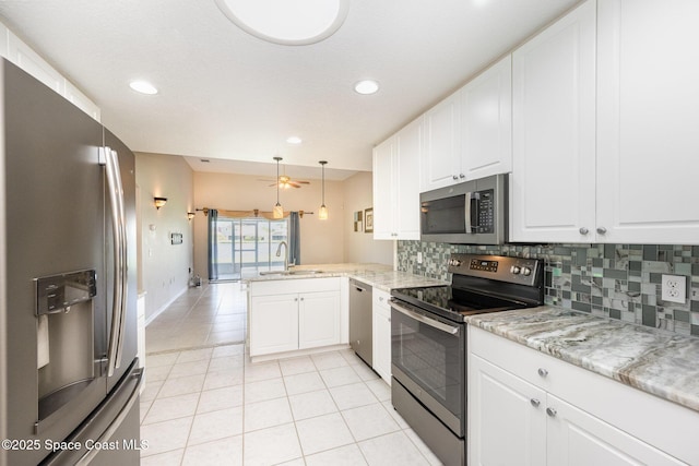 kitchen featuring stainless steel appliances, white cabinets, a peninsula, and decorative light fixtures