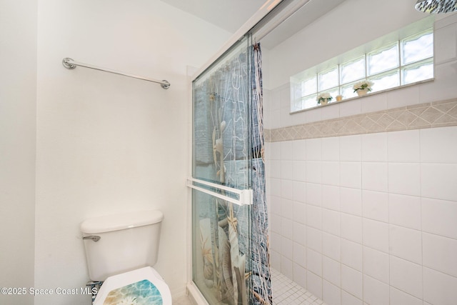 bathroom featuring a tile shower and toilet