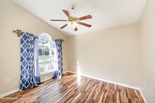 spare room with a ceiling fan, lofted ceiling, baseboards, and wood finished floors