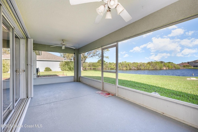 unfurnished sunroom with a ceiling fan and a water view