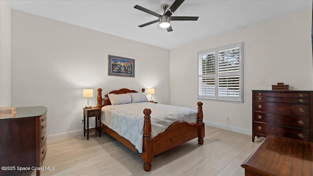 bedroom with a ceiling fan, light wood-style flooring, and baseboards