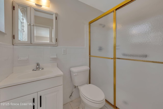 bathroom featuring toilet, a wainscoted wall, a shower stall, and vanity