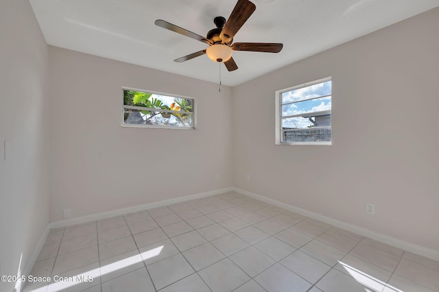 empty room with light tile patterned floors, ceiling fan, and baseboards