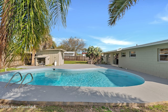 view of pool with a fenced backyard, a storage unit, a fenced in pool, and an outdoor structure