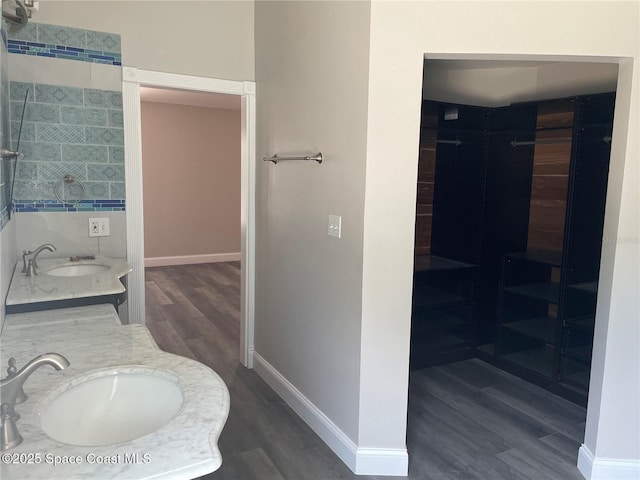 full bath featuring wood finished floors, vanity, and baseboards