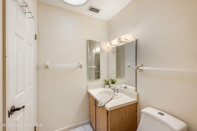 half bath with toilet, tile patterned flooring, vanity, and visible vents