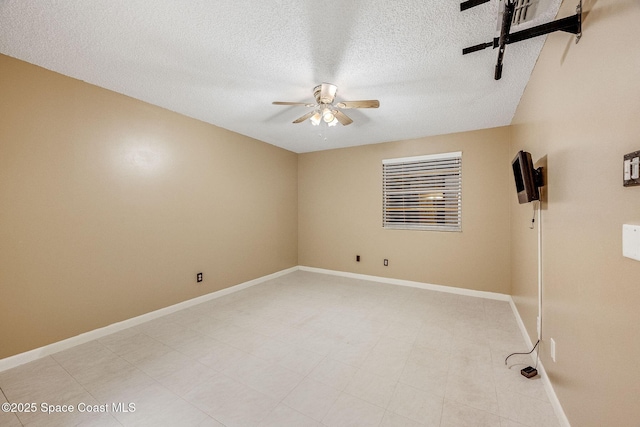 unfurnished room featuring a ceiling fan, a textured ceiling, and baseboards