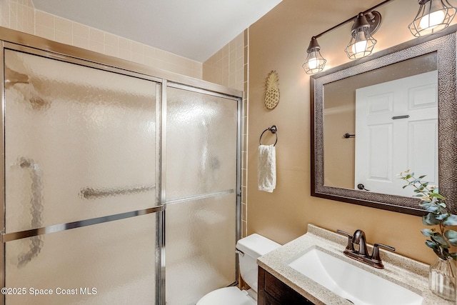 bathroom featuring a stall shower, vanity, and toilet