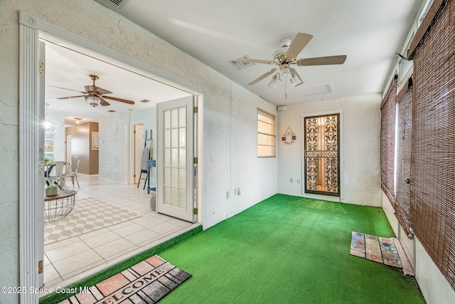 spare room with a ceiling fan, attic access, light colored carpet, and visible vents