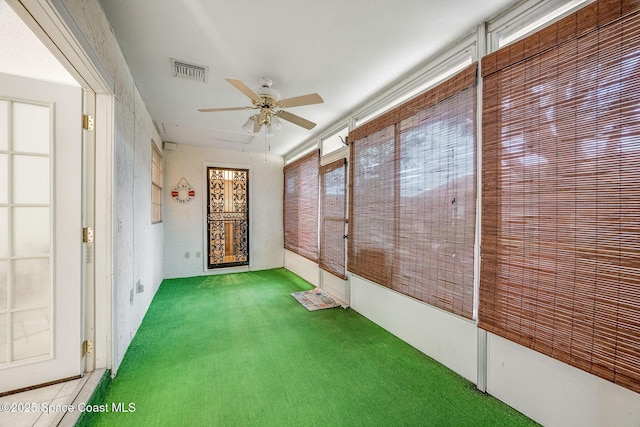 unfurnished sunroom featuring visible vents and ceiling fan