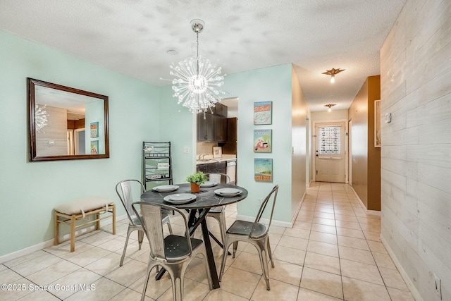 dining space with light tile patterned floors, baseboards, a chandelier, and a textured ceiling