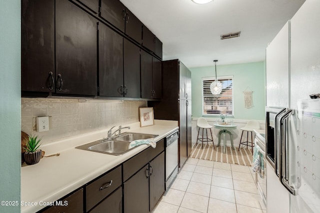 kitchen with visible vents, dishwasher, decorative light fixtures, light countertops, and a sink