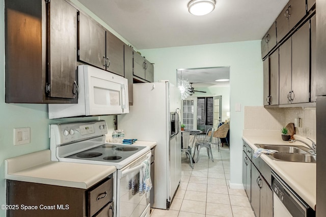 kitchen with a sink, white appliances, light countertops, and decorative backsplash