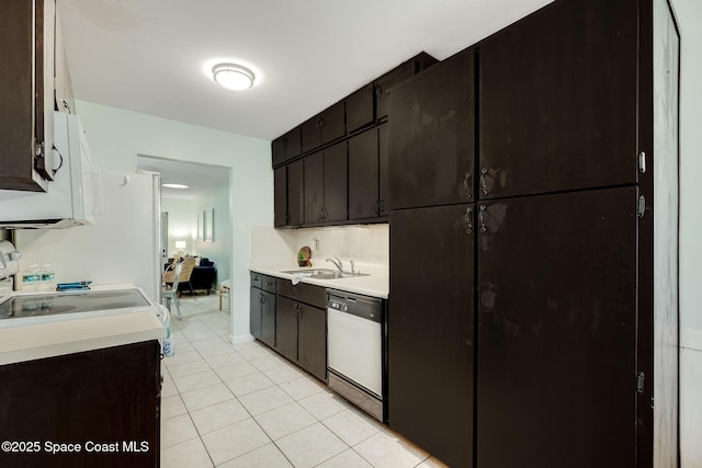 kitchen with light tile patterned floors, tasteful backsplash, dishwashing machine, light countertops, and a sink