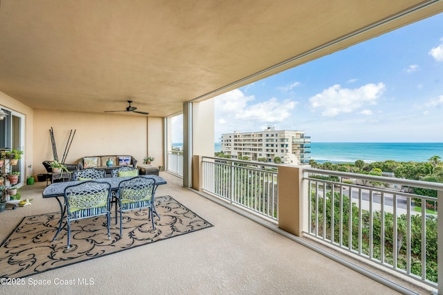 balcony with ceiling fan and a water view