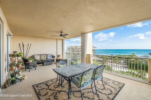 exterior space with an outdoor living space, a water view, ceiling fan, and a beach view