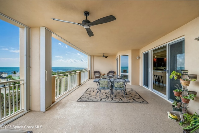 balcony with a water view and outdoor dining space