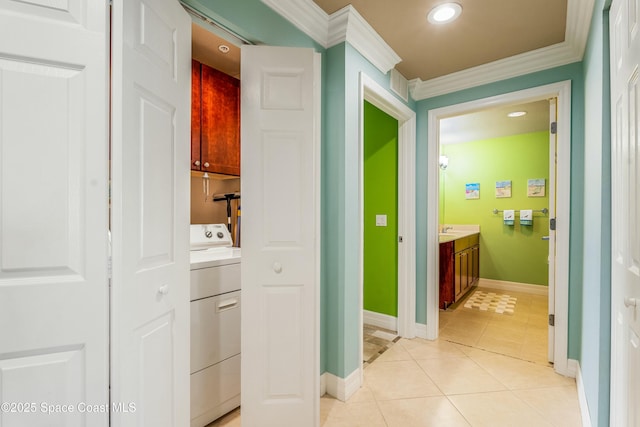 hallway featuring light tile patterned floors, baseboards, washer / clothes dryer, ornamental molding, and recessed lighting