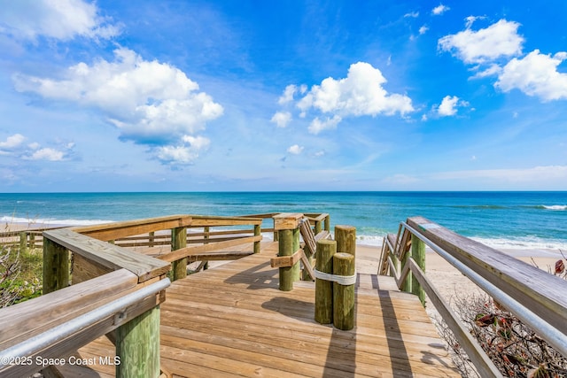 view of property's community featuring a water view and a beach view