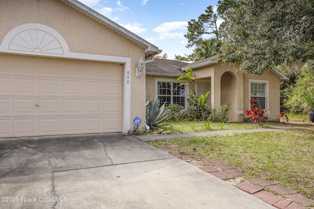 ranch-style home featuring a garage, concrete driveway, a front lawn, and stucco siding