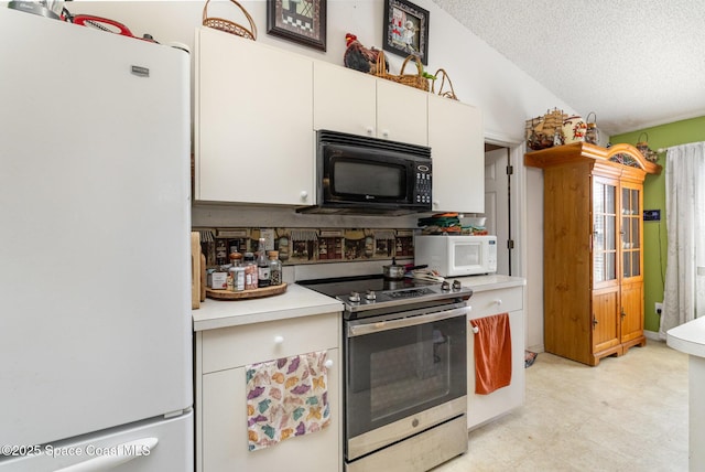 kitchen with white appliances, light countertops, a textured ceiling, light floors, and white cabinetry