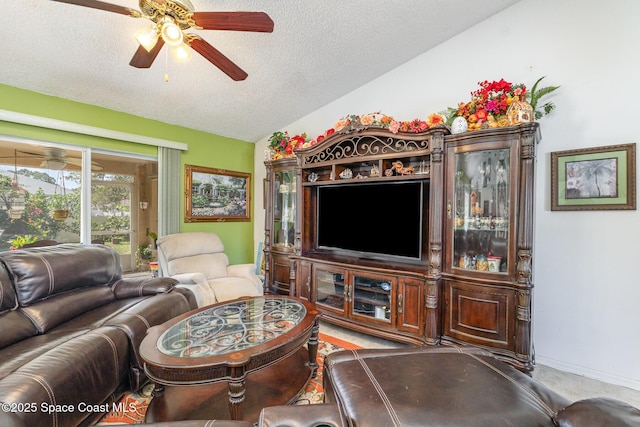 living area with baseboards, lofted ceiling, ceiling fan, carpet, and a textured ceiling