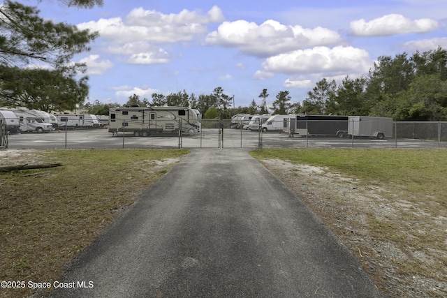 view of street featuring driveway, a gated entry, and a gate