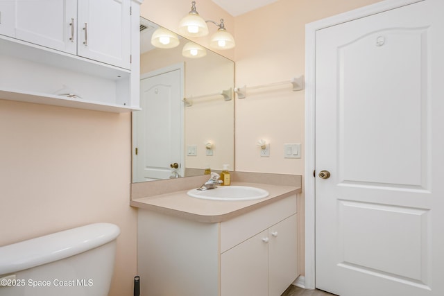 bathroom featuring toilet, visible vents, and vanity