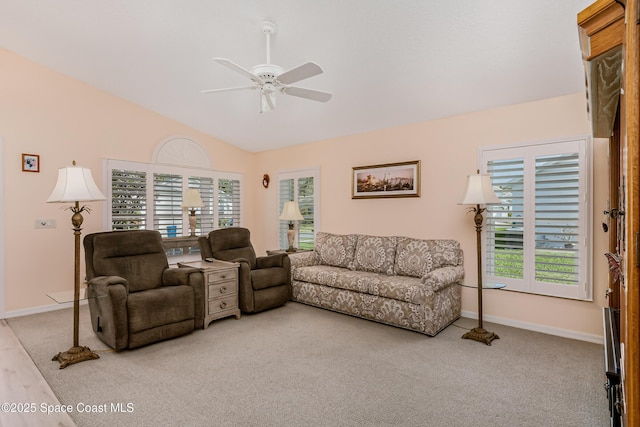 living area with a wealth of natural light, vaulted ceiling, baseboards, and ceiling fan