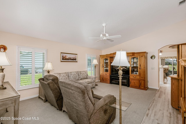 living area featuring a healthy amount of sunlight, visible vents, vaulted ceiling, and a ceiling fan