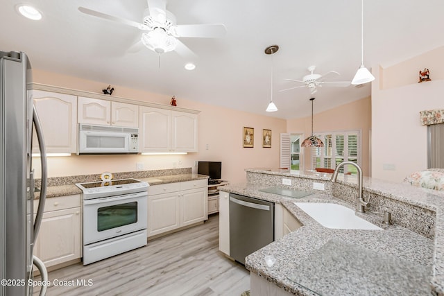 kitchen featuring decorative light fixtures, appliances with stainless steel finishes, vaulted ceiling, a sink, and ceiling fan