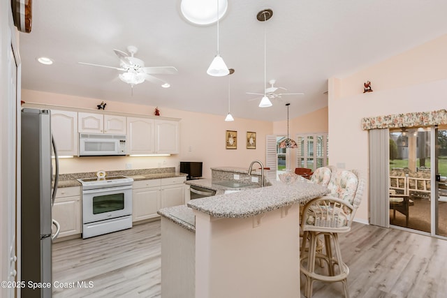 kitchen with white cabinets, ceiling fan, appliances with stainless steel finishes, vaulted ceiling, and a sink