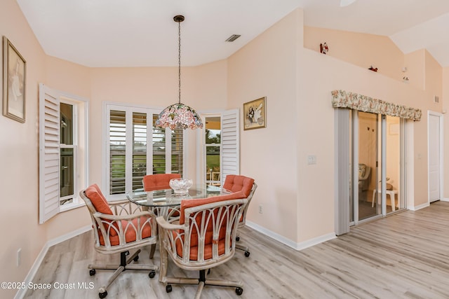 dining area featuring vaulted ceiling, visible vents, light wood-style flooring, and baseboards