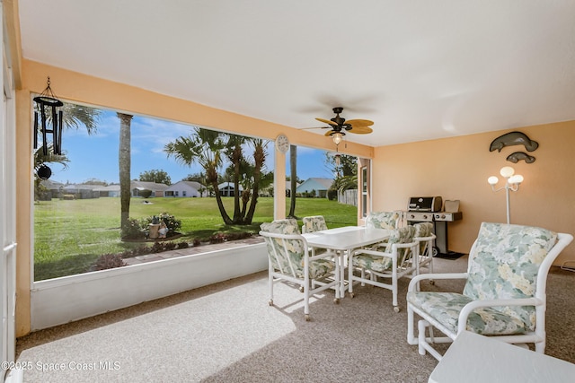 sunroom / solarium featuring a ceiling fan