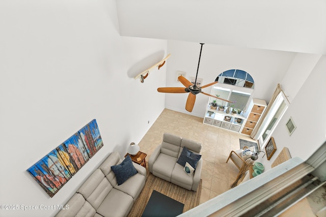 living area with ceiling fan, visible vents, and baseboards