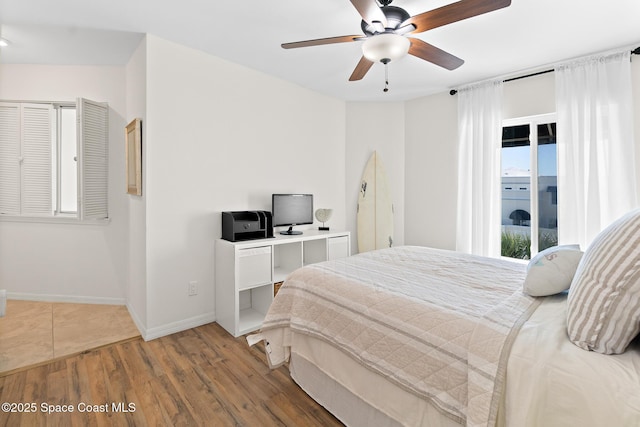 bedroom featuring access to exterior, ceiling fan, baseboards, and wood finished floors