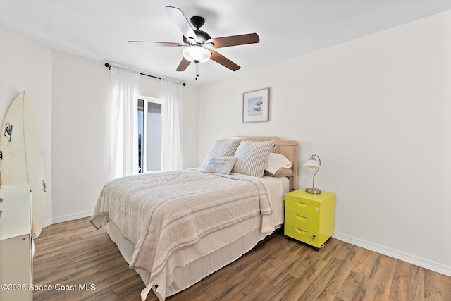 bedroom featuring baseboards, dark wood finished floors, and a ceiling fan