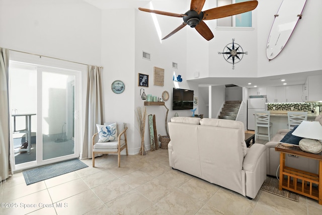 living room featuring stairs, visible vents, and a ceiling fan