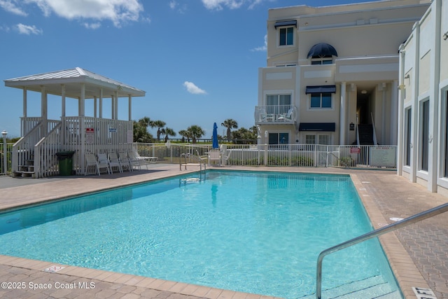 community pool featuring fence and a patio