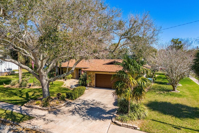 view of front of home with a front yard, stone siding, driveway, and an attached garage