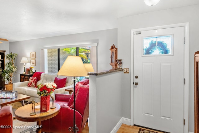 foyer entrance with baseboards and light wood-style floors