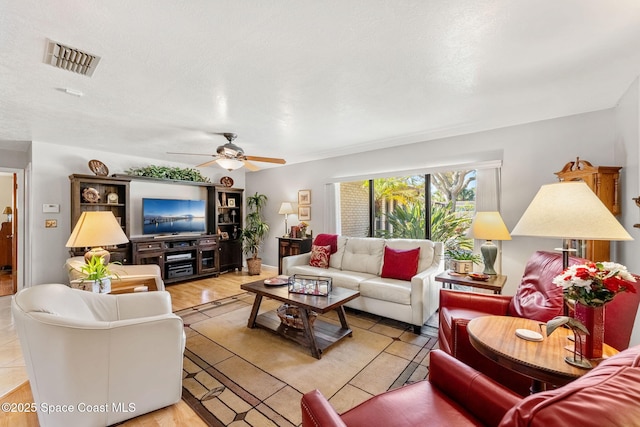 living room with a ceiling fan and visible vents