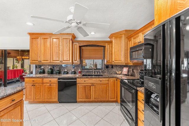 kitchen featuring black appliances, tasteful backsplash, light tile patterned floors, and a sink